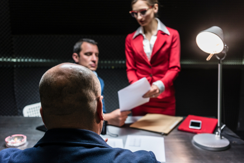 Image of a San Antonio Criminal Defense Lawyer reviewing a criminal case file with clients accused of criminal charges in a law office setting. 