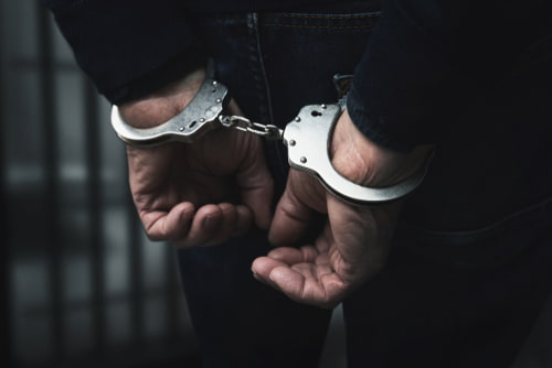 Texas 3 strikes law with a man in handcuffs.