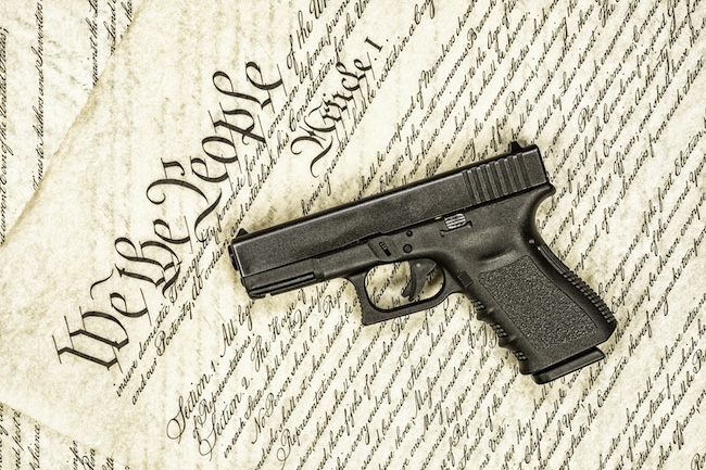 Federal law books with handgun representing the interaction of federal and Texas gun laws for legal guidance