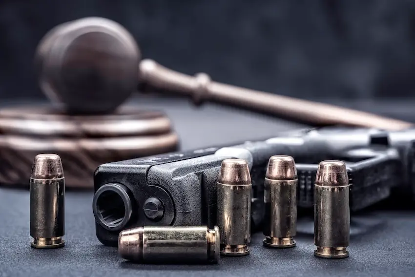 Scales of justice and handgun symbolizing federal and Texas gun laws legal compliance