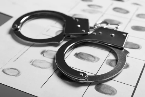 Handcuffs and fingerprints representing hardest criminal charges to beat.