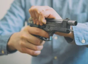 Gun charges lawyer, gun crime defense, gun charges, A man racking a pistol