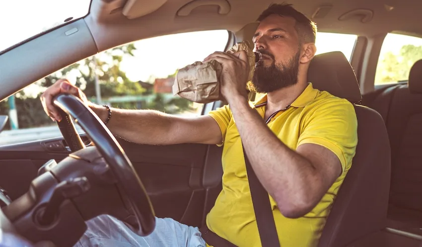 A man in a yellow shirt is about to face a DWI arrest for drinking while driving.